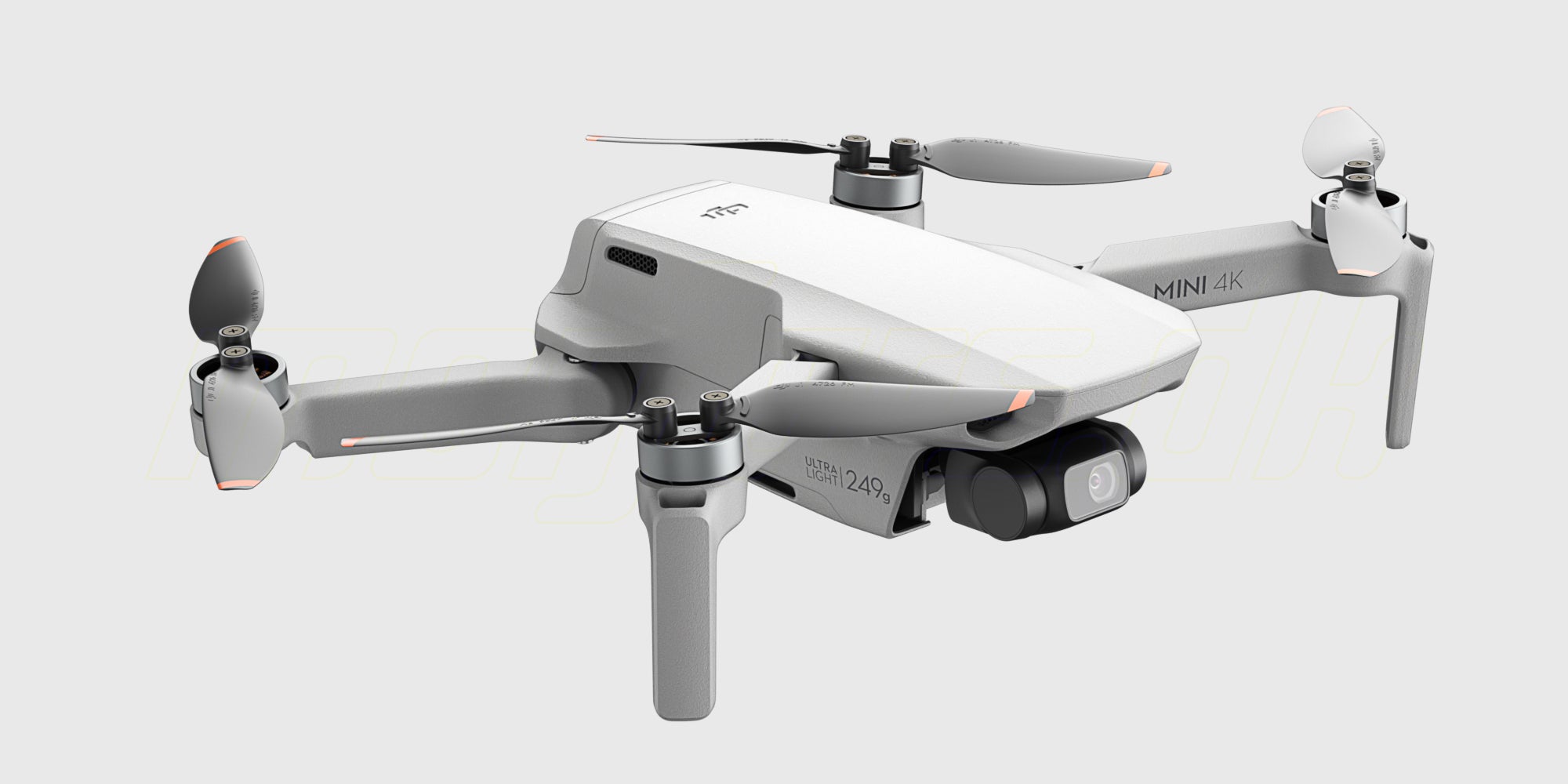 Grå DJI Mini 4K drone med fjernkontrol og tilbehør fra Fly More Combo vist på hvid baggrund.