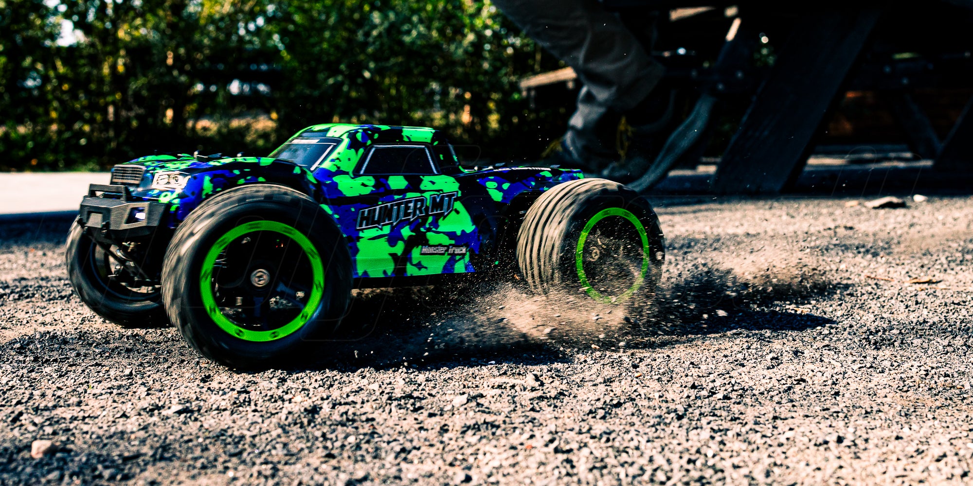 Hunter MT10 fjernstyret monster truck i fuld fart gennem støvet på en grusvej.