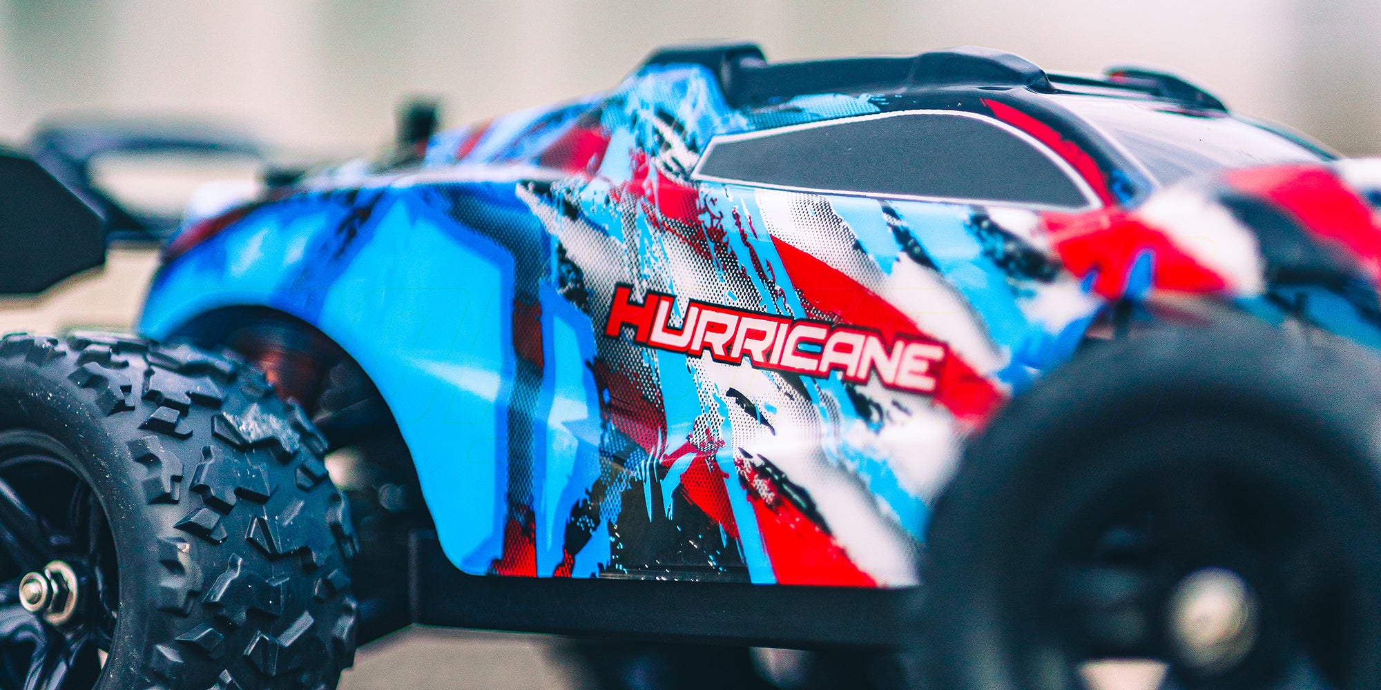 Grøn Hurricane fjernstyret bil kører hurtigt gennem støvet i råt terræn.