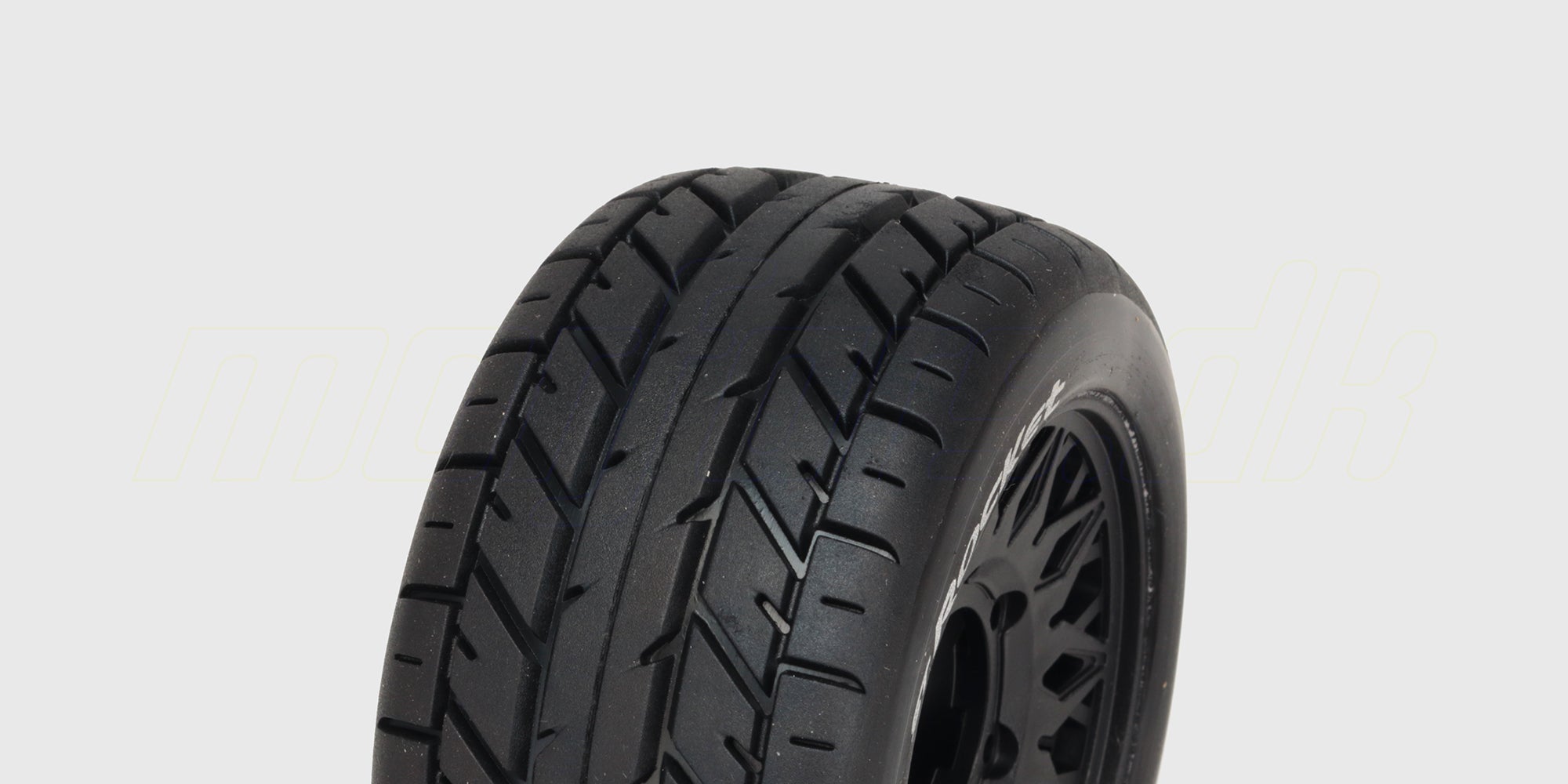 To sorte ST-Rocket dæk med hvide fælge til fjernstyret bil vist fra siden.