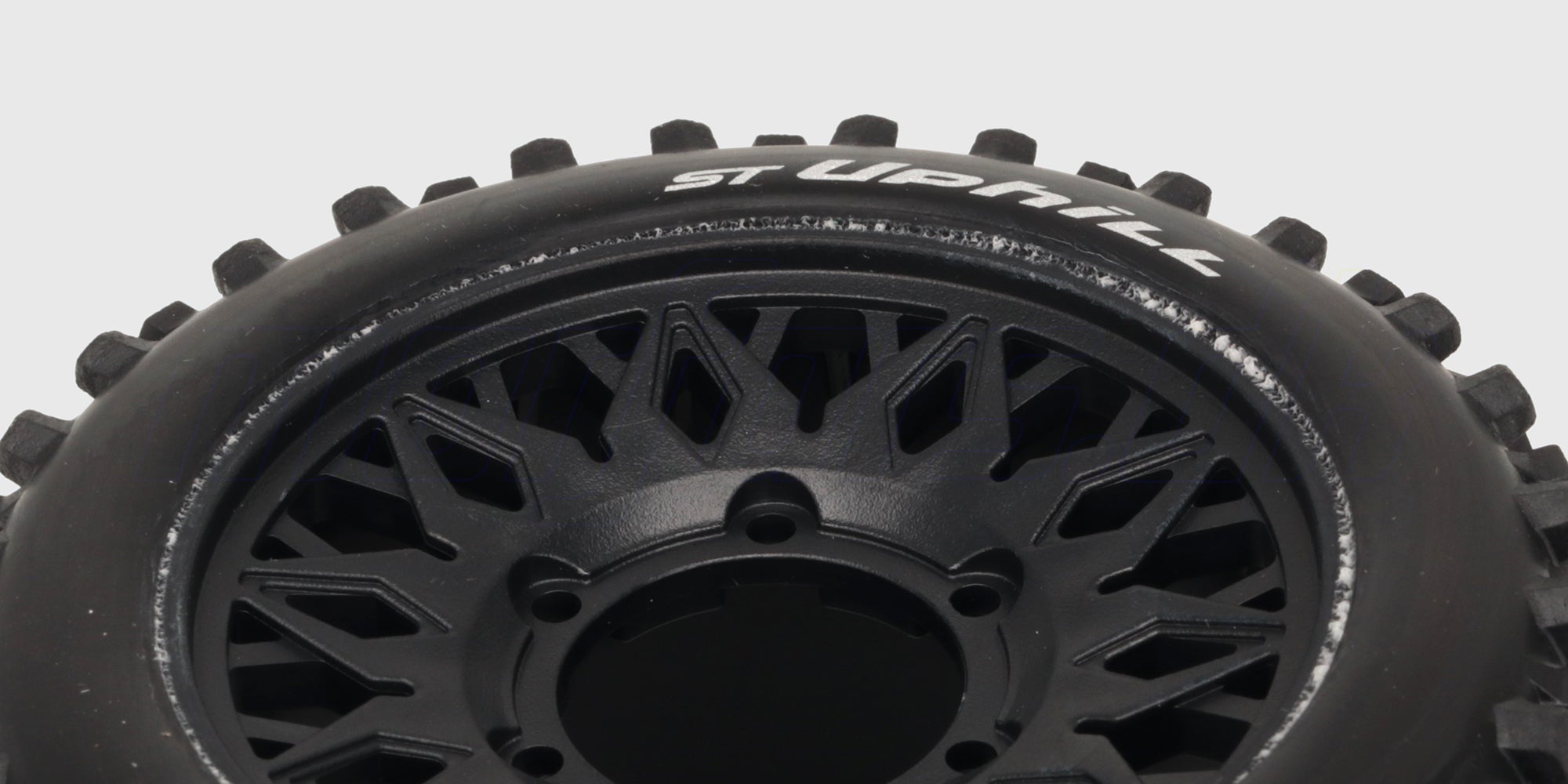 ST-Uphill hjulsæt med sorte fælge og groft dækmønster til offroad fjernstyrede biler.
