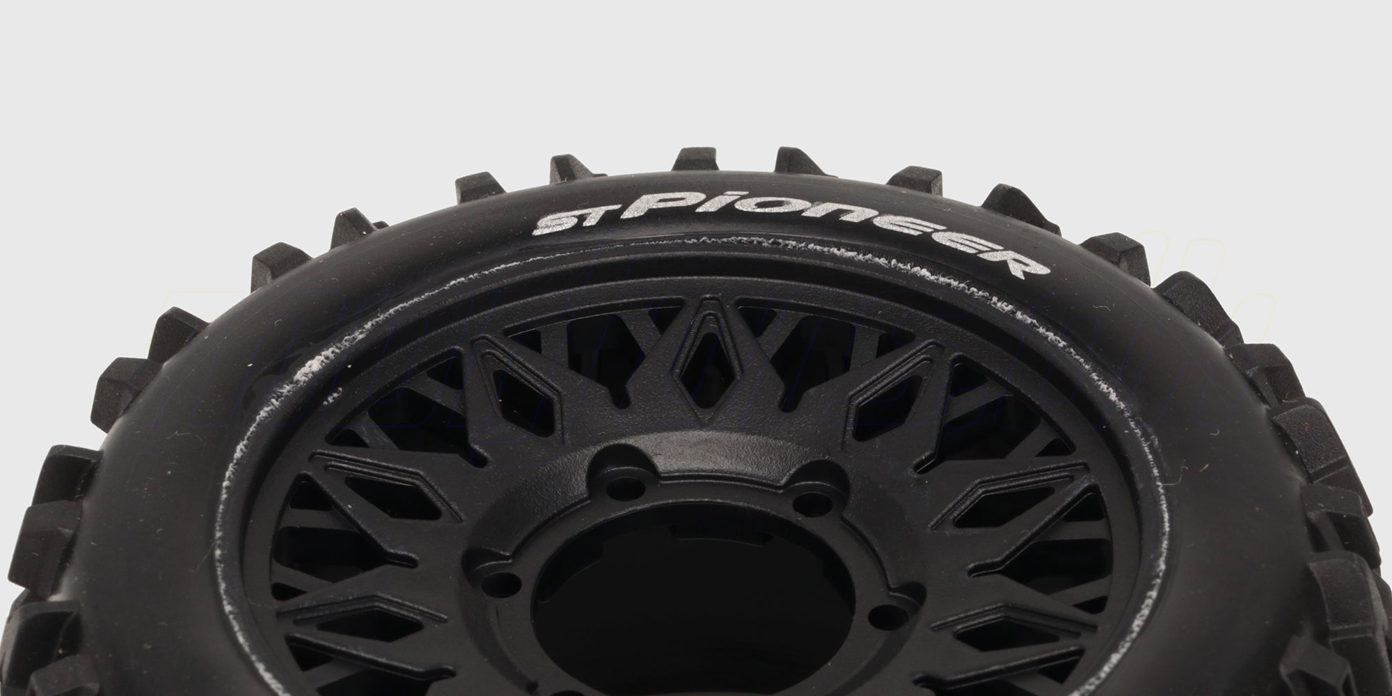 To sorte ST-Pioneer offroad dæk med groft mønster og detaljerede fælge til fjernstyret bil.