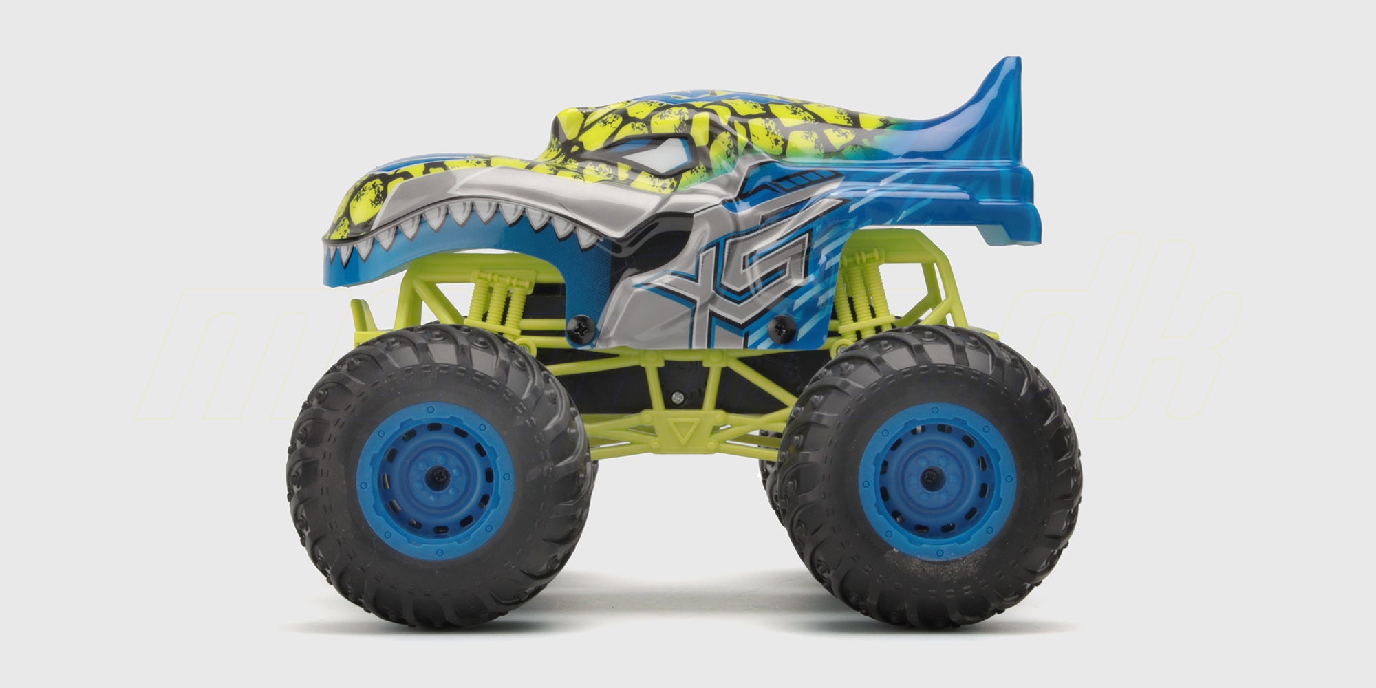 Grøn Flash4 monster truck med store dæk kører gennem græs og sprøjter med vand.