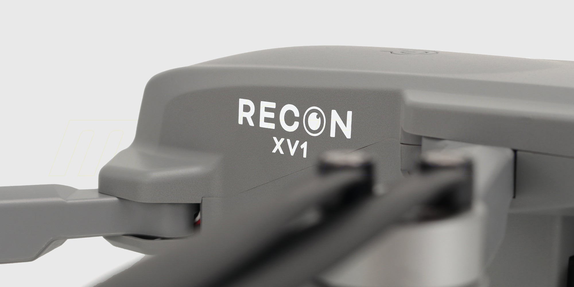 Grå Drone Recon XV1 med foldbare arme og kamera set skråt forfra på hvid baggrund.