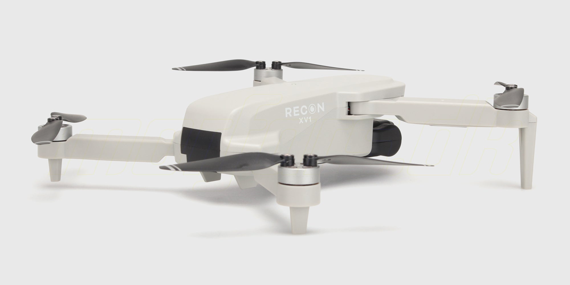 Hvid Drone Recon XV1 med kamera og foldbare arme vist fra siden mod en lys baggrund.