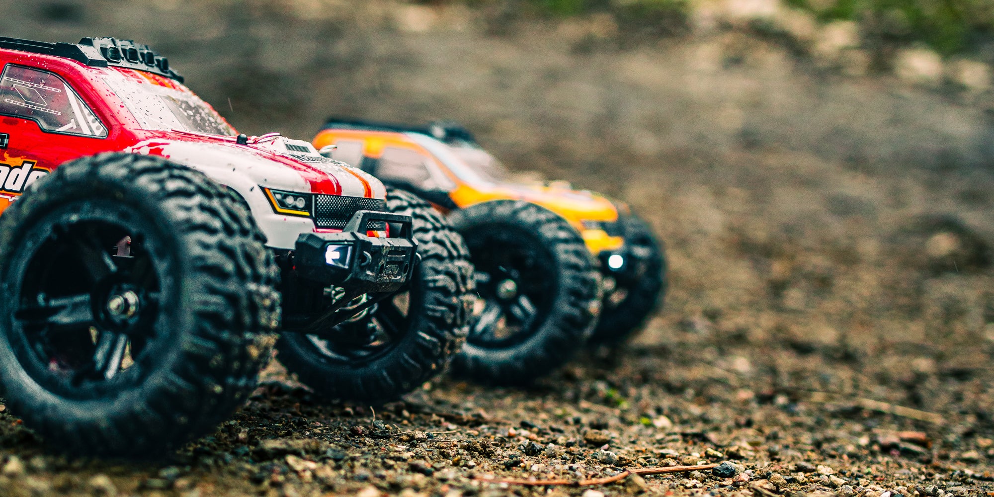 Grøn Tornado Brushless fjernstyret bil i fuld fart gennem mudder og vand på en offroad bane.