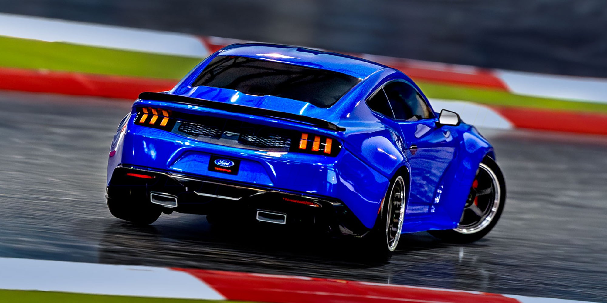 Blå Traxxas Mustang 4-Tec Drift fjernstyret bil med realistiske detaljer vist i fart.