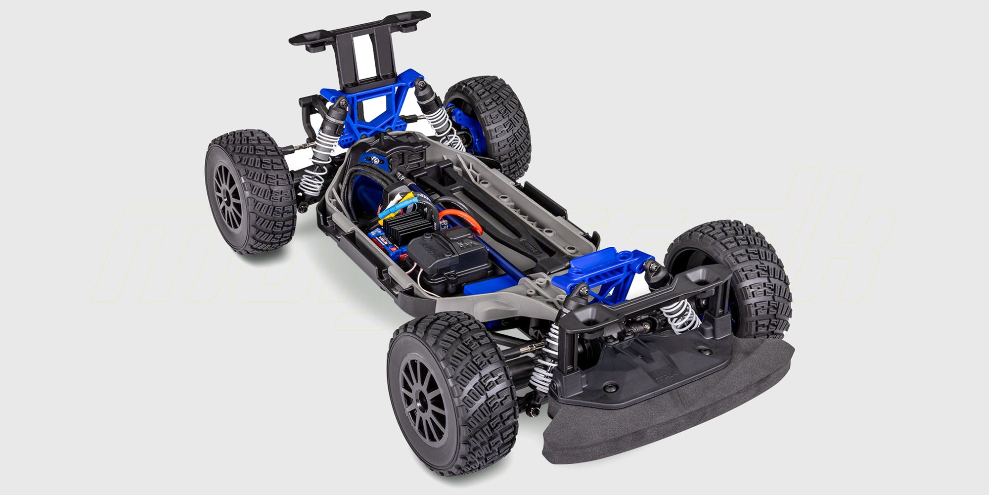 Blå Traxxas Ford Fiesta ST Rally Brushless fjernstyret bil i fuld fart på en grusbane.