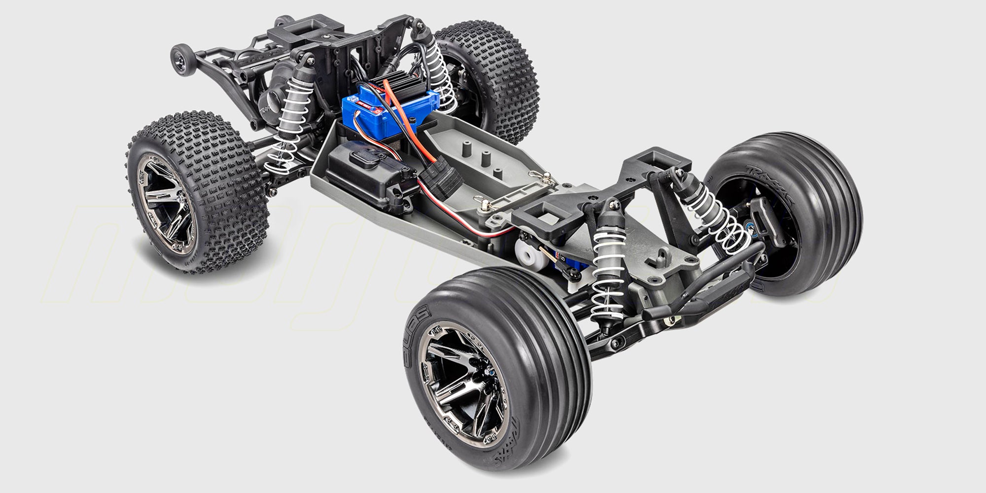 Blå Traxxas Rustler Brushless fjernstyret stadium truck med offroad-dæk set fra siden på hvid baggrund.