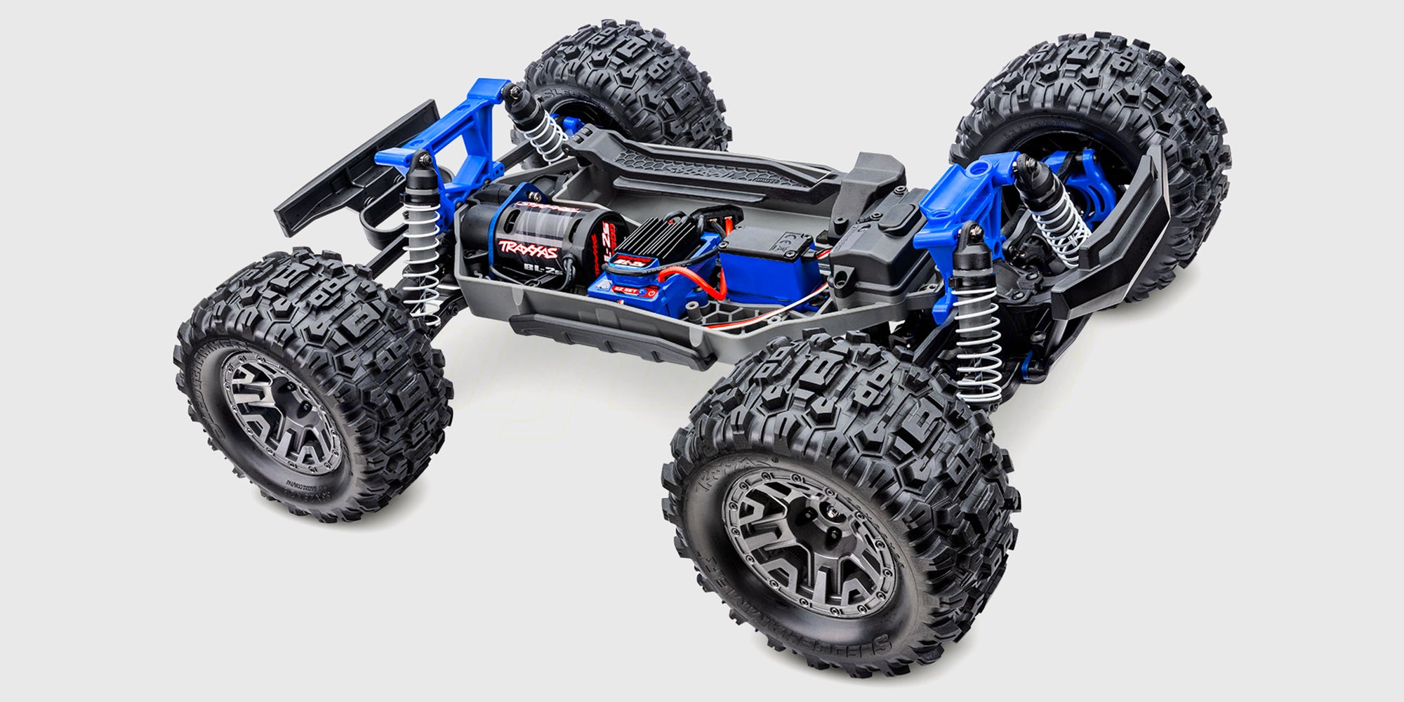 Blå Traxxas Stampede 4x4 BL-2S monster truck med store offroad-dæk vist forfra på en hvid baggrund.