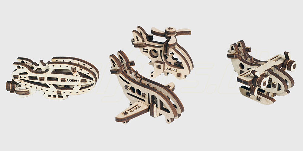 Fire små mekaniske flymodeller i lyst træ fra Ugears Tribiks byggesæt til begyndere.