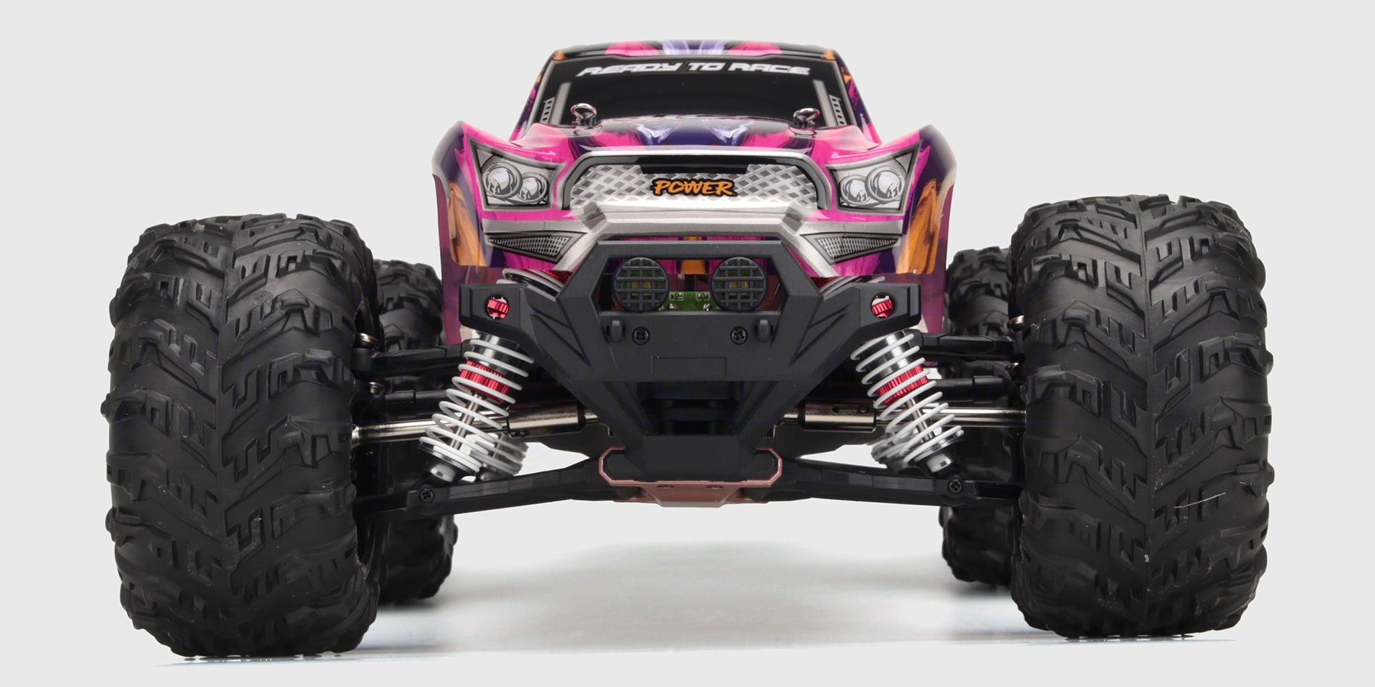 Lilla XLH Race Truck fjernstyret bil med store offroad-hjul og kraftig affjedring set skråt forfra.