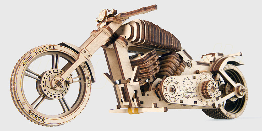 Mekanisk byggesæt af Ugears Bike VM-02 motorcykel i lyst træ med synlige tandhjul og detaljer.