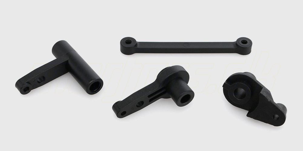 Sort styretøjssæt med styrearme og plastikdele til vedligeholdelse af en fjernstyret bil.