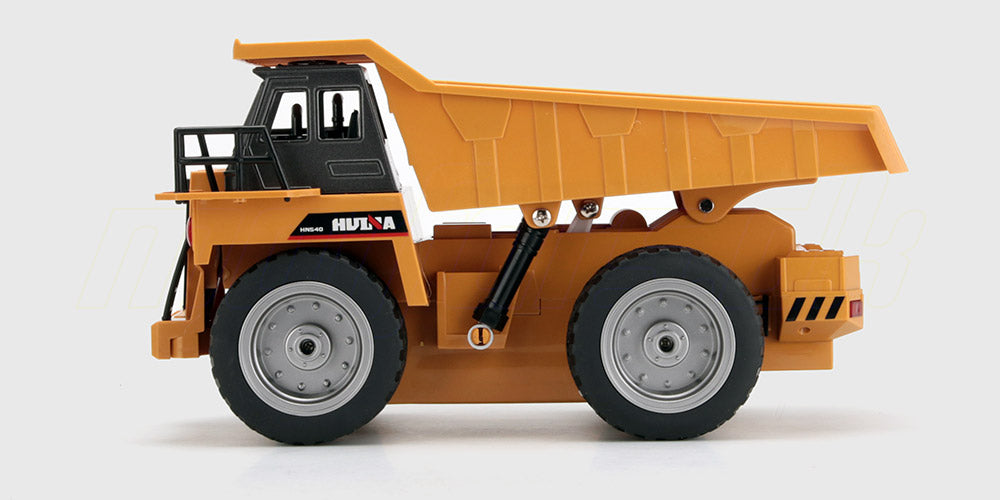 Gul fjernstyret dumper i plast med bevægeligt lad til leg på hvid baggrund.