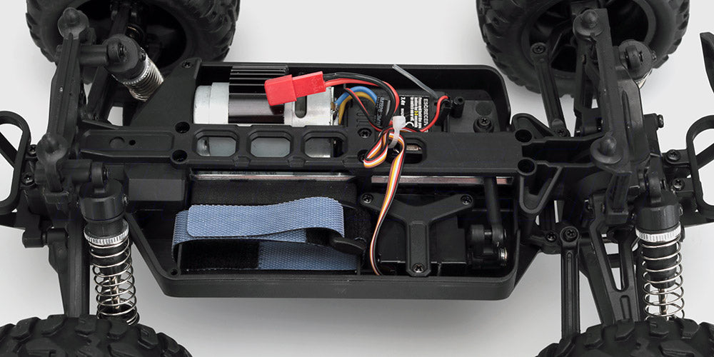 Sort og rød Ravage fjernstyret bil til børn kører hurtigt på græsset med realistiske detaljer og store dæk.