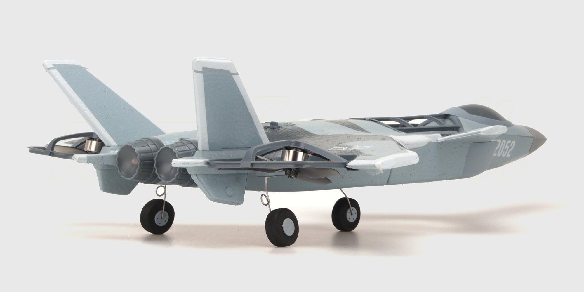 Grå og hvid Fighter Jet Brushless fjernstyret fly i luften med detaljerede vinger og cockpit.