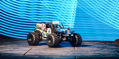Hurricane XL Monster Truck Brushless i blå kørsel gennem vandpyt med LED-lys tændt.