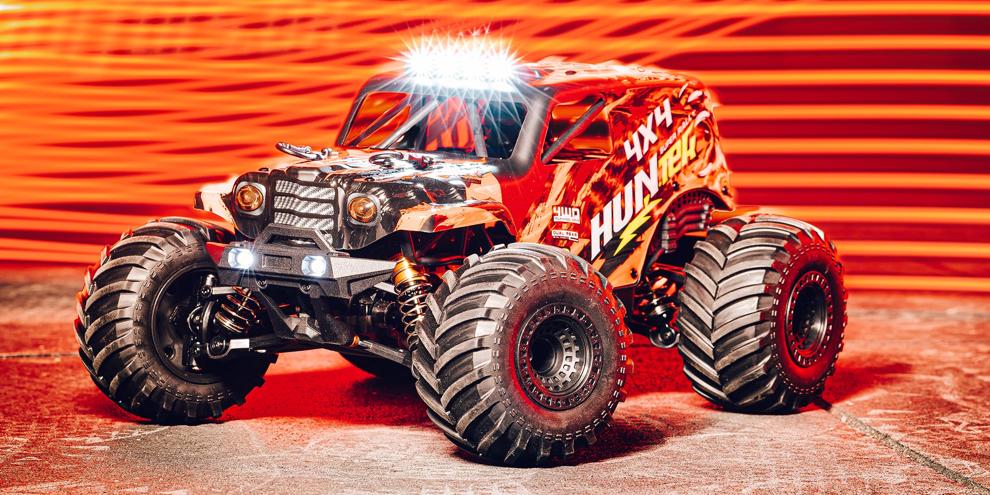 Hurricane XL Monster Truck kører gennem mudder og vandpytter i et bakket terræn.