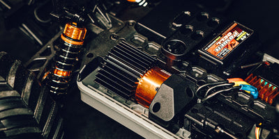 Orange Hurricane XL Monster Truck Brushless fjernstyret bil i fuld fart på en grusvej.