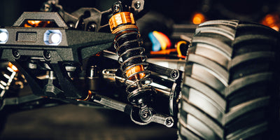 Hurricane XL Monster Truck kører gennem vandpytter og mudder i terræn med høj fart.