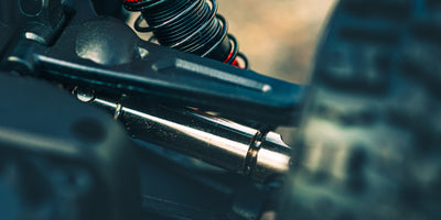 Fjernstyret HyperGo EXtreme monster truck i fuld fart gennem vandpyt og mudder i terræn.