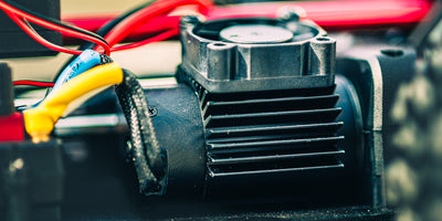 HyperGo EXtreme fjernstyret bil kører gennem mudder og vand med høj fart i terræn.