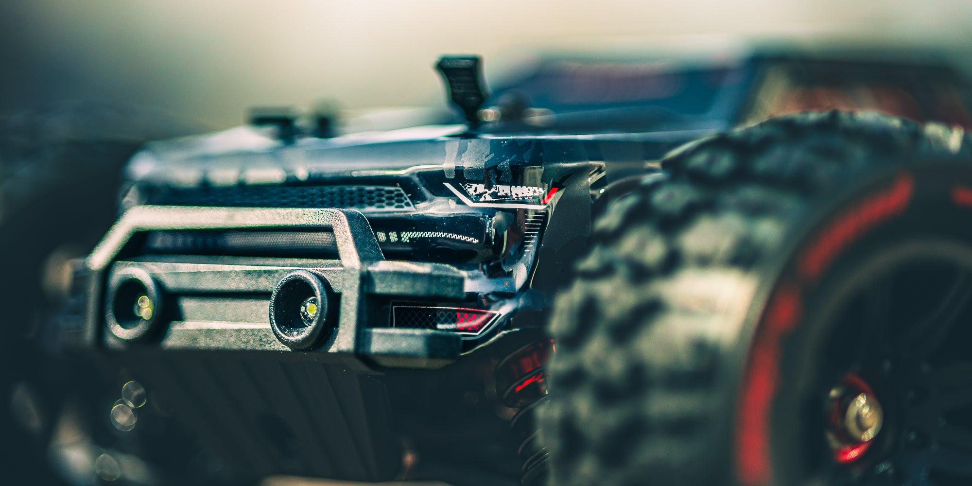 HyperGo EXtreme fjernstyret bil i fuld fart gennem en vandpyt med vandsprøjt på en grusvej.