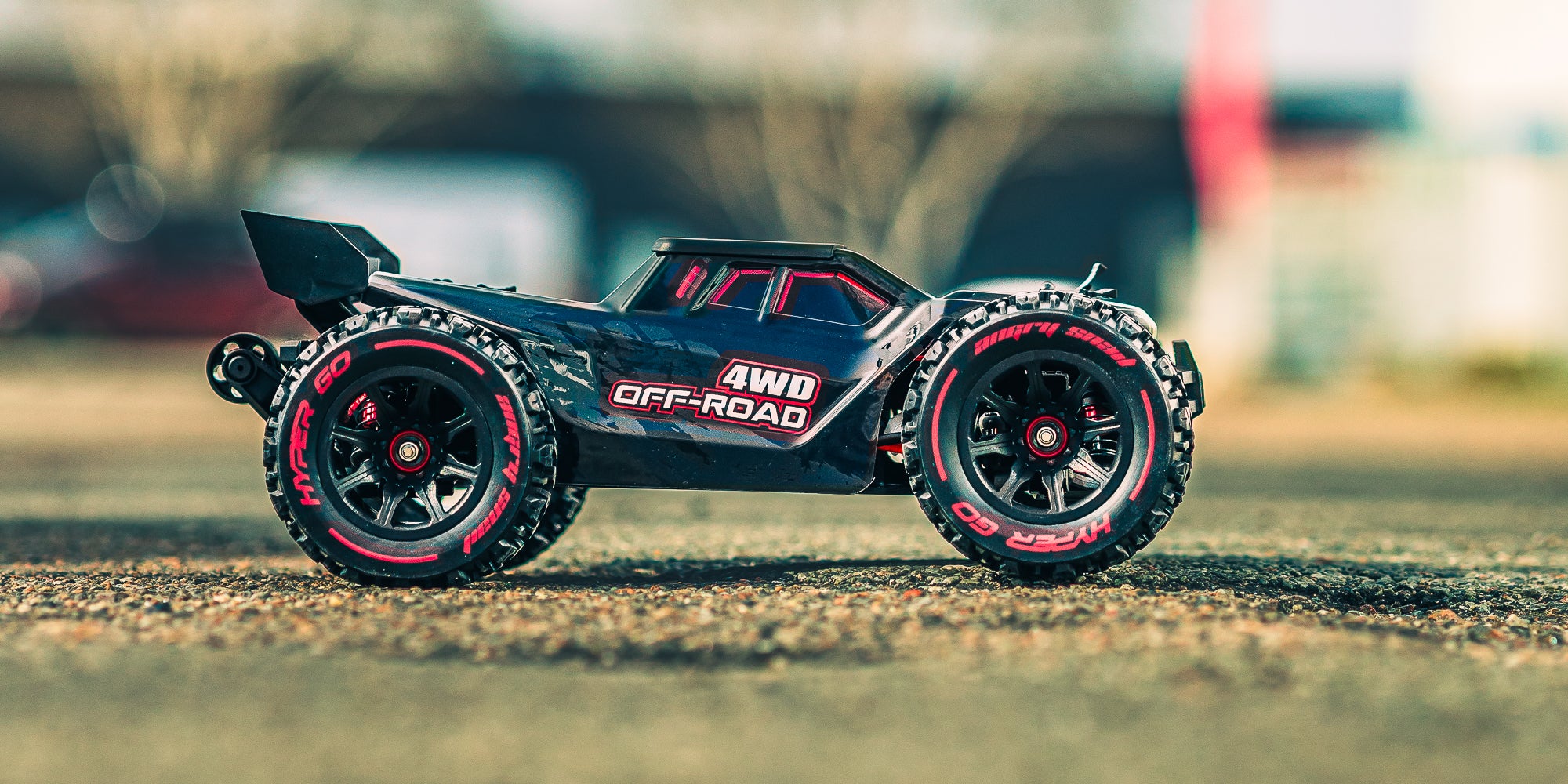 HyperGo EXtreme fjernstyret bil i fuld fart på en grusvej med støv hvirvlende bag hjulene.