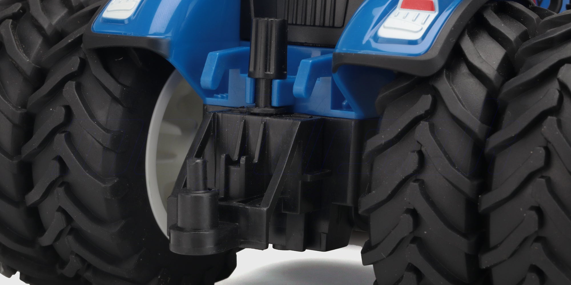 Blå Korody fjernstyret traktor i skala 1:24 med monteret gødningsspreder og lysende forlygter.