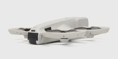 Hvid Drone M6 Zoomer quadcopter med fire propeller og orange detaljer på hvid baggrund.