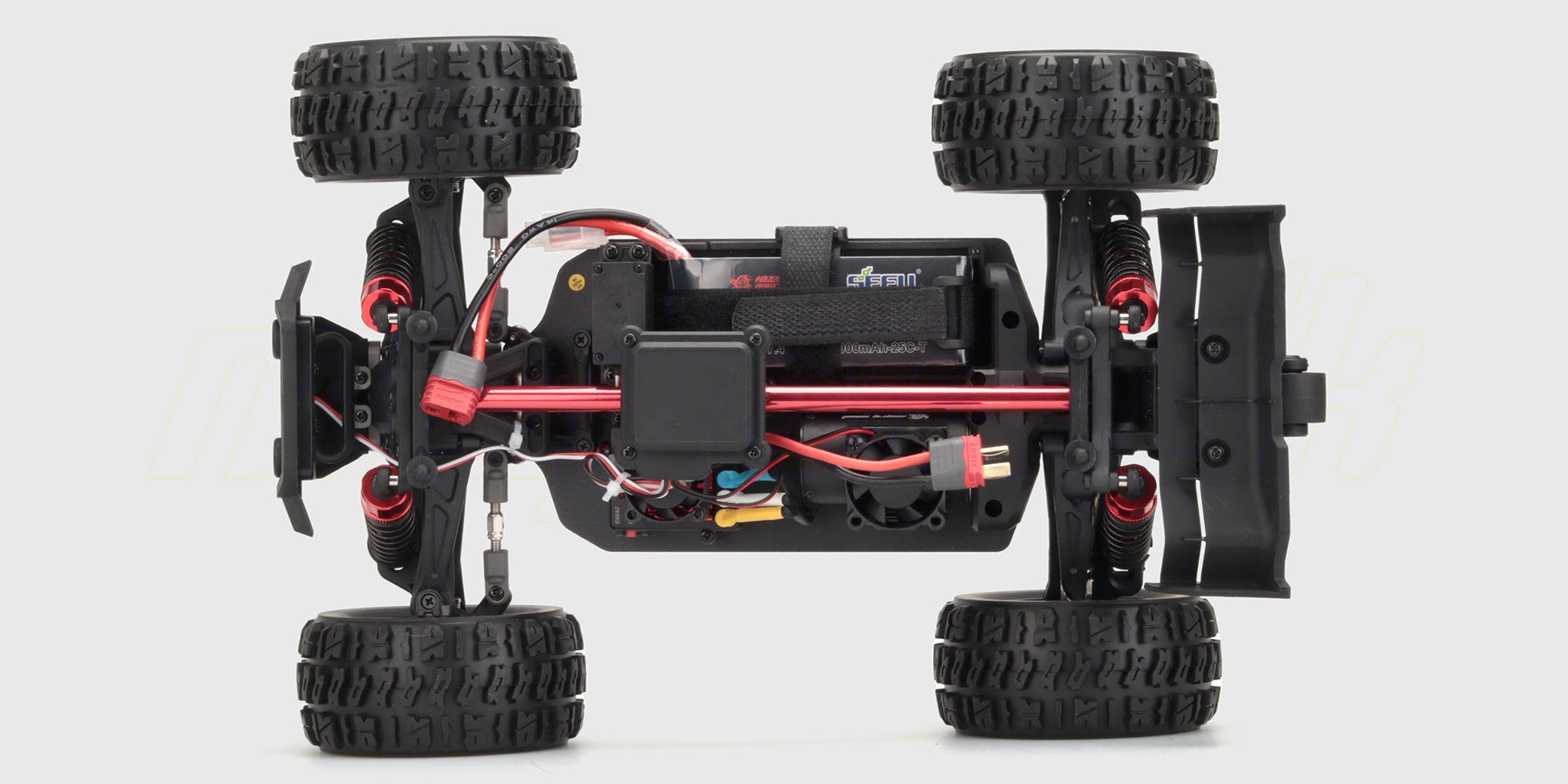 HyperGo EXtreme fjernstyret bil i sort og grøn med robuste offroad dæk vist tæt på i terræn.