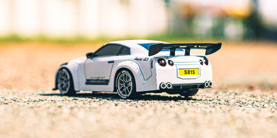 Sort BTD Drifter fjernstyret bil i fuld fart på en indendørs driftbane med realistiske detaljer.