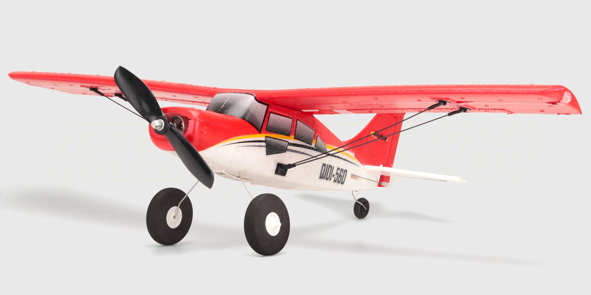 Hvidt Qidi-560 Brushless sportsfly med røde detaljer i luften mod en klar blå himmel.