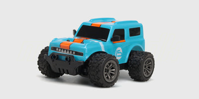 Sort Rapid Monster Truck med grønne detaljer og store offroad-hjul vist skråt forfra på en hvid baggrund.