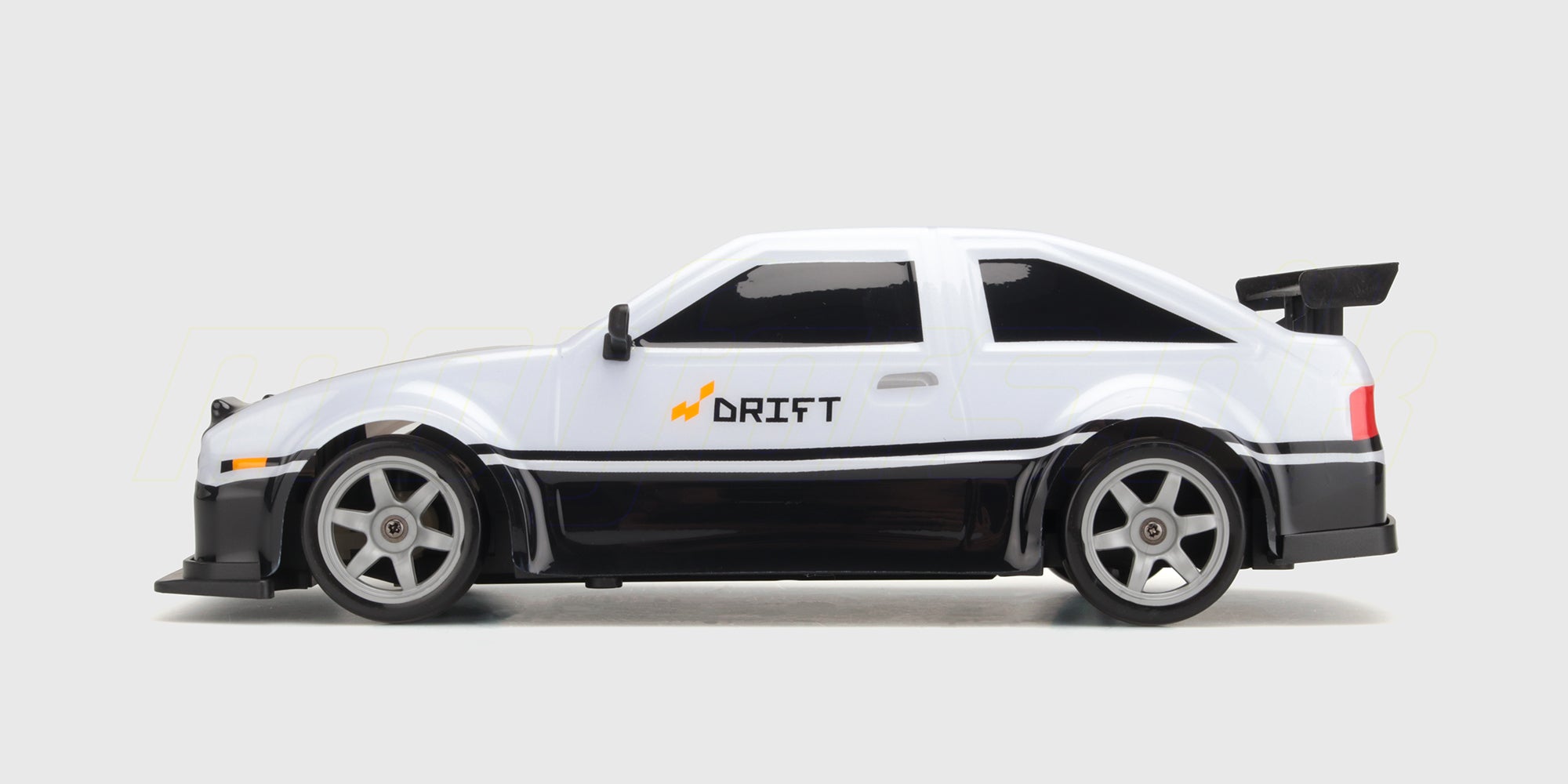 Grå Super Drifter fjernstyret driftbil med aerodynamisk vinge og detaljerede fælge set skråt forfra.