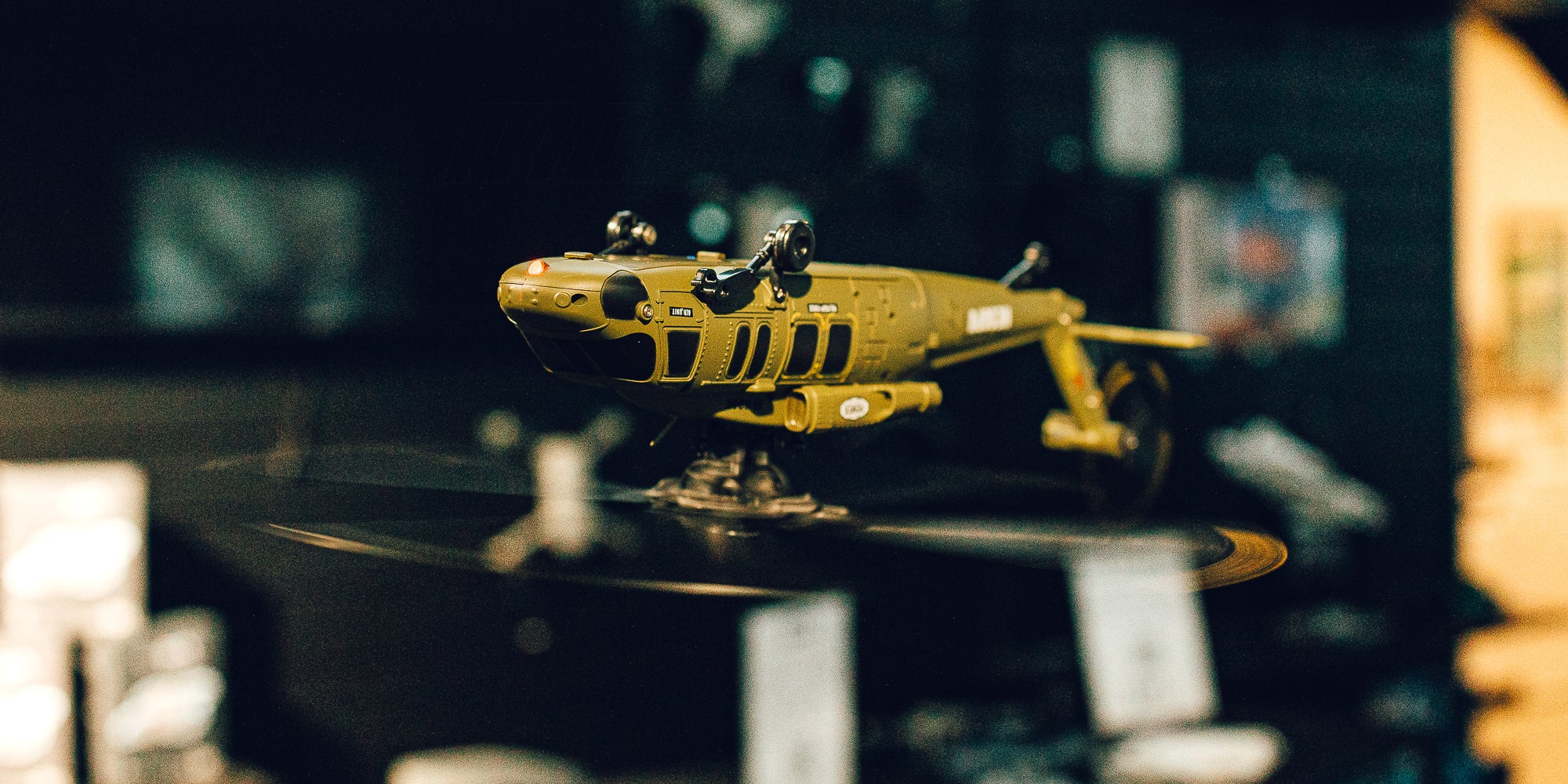 Sort og rød Top Hunter fjernstyret helikopter med dobbelt rotor og landingsstel på en hvid baggrund.