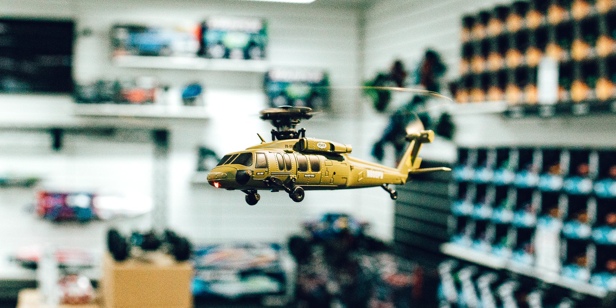 Sort og rød Top Hunter fjernstyret helikopter med fjernbetjening og tilbehør vist på hvid baggrund.