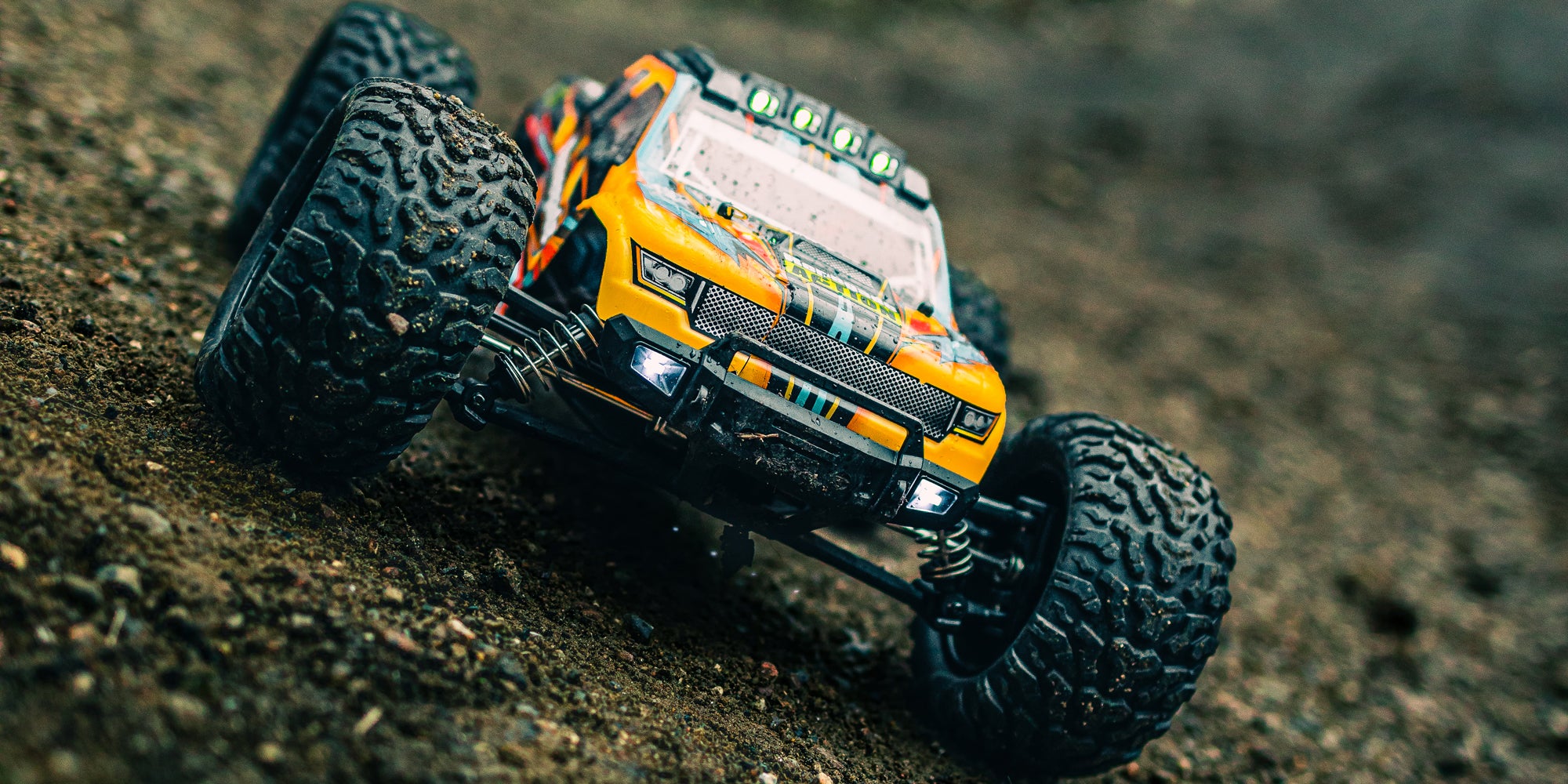 Grøn Tornado Brushless monster truck kører gennem en vandpyt og viser sin vandbeskyttede elektronik.