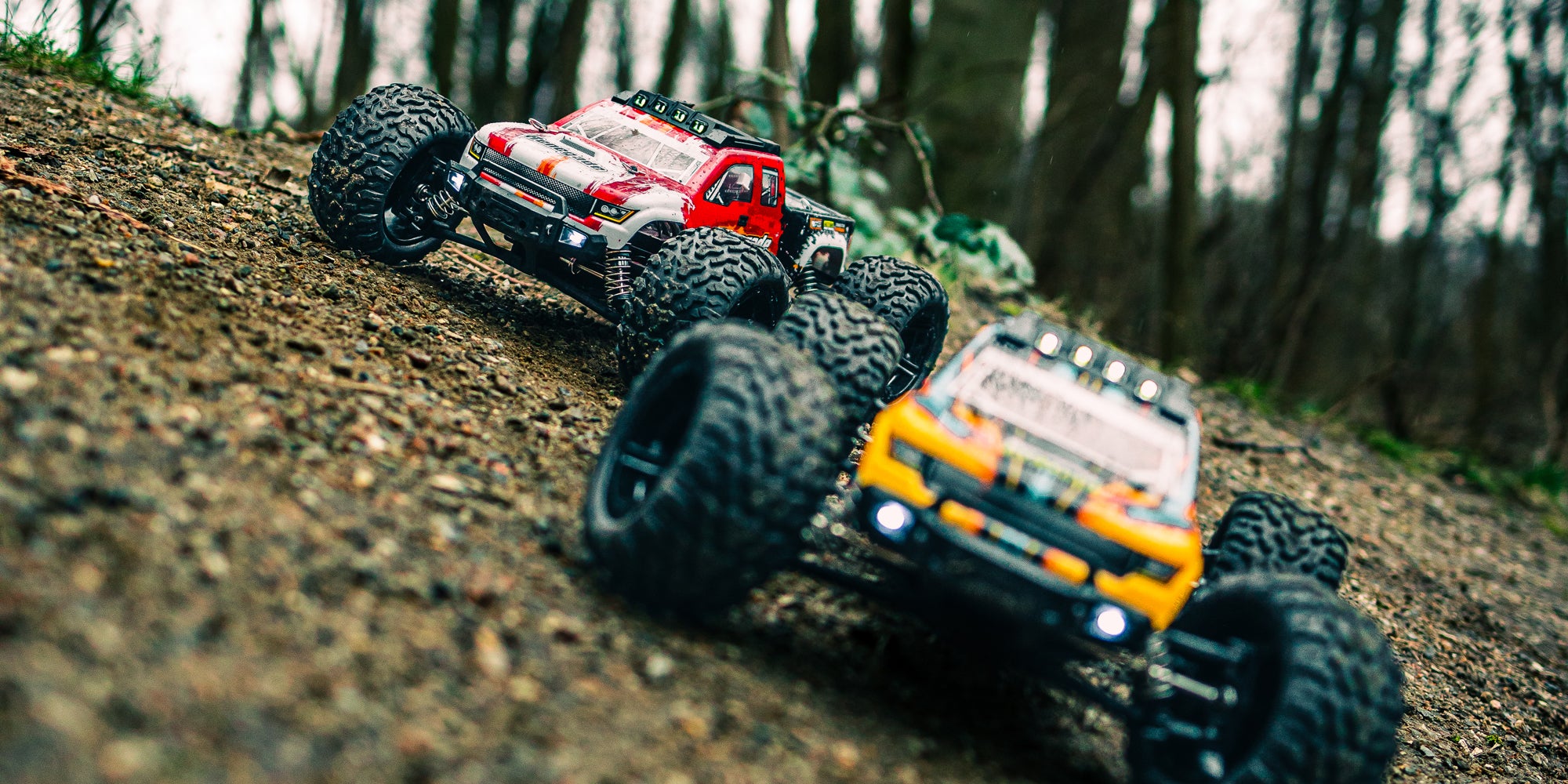 Sort Tornado Brushless monster truck i fuld fart på en grusvej med støvskyer bag de store hjul.