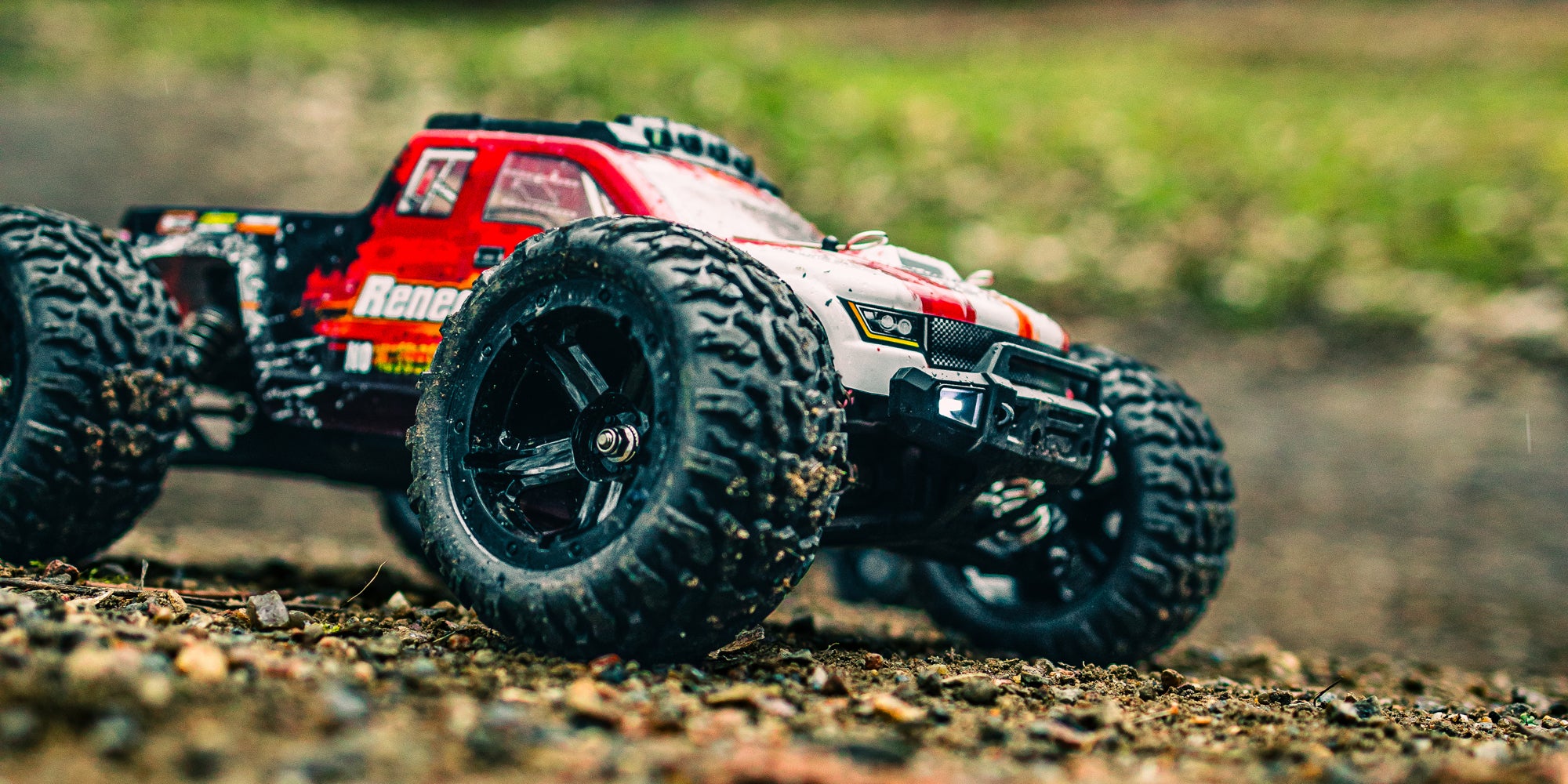 Tornado Brushless fjernstyret bil i fuld fart på en grusvej med støvskyer bag de fire hjul.