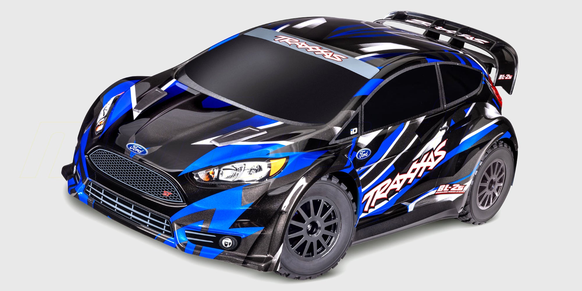 Traxxas Ford Fiesta ST Rally Brushless fjernstyret bil i blå og hvid med dæk i hurtig fart på grus.