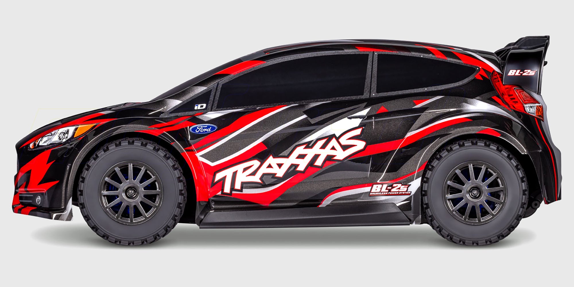 Blå Traxxas Ford Fiesta ST Rally Brushless fjernstyret bil set skråt forfra på hvid baggrund.