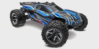Blå Traxxas Rustler 4x4 VXL fjernstyret bil med store offroad dæk set skråt forfra på hvid baggrund.