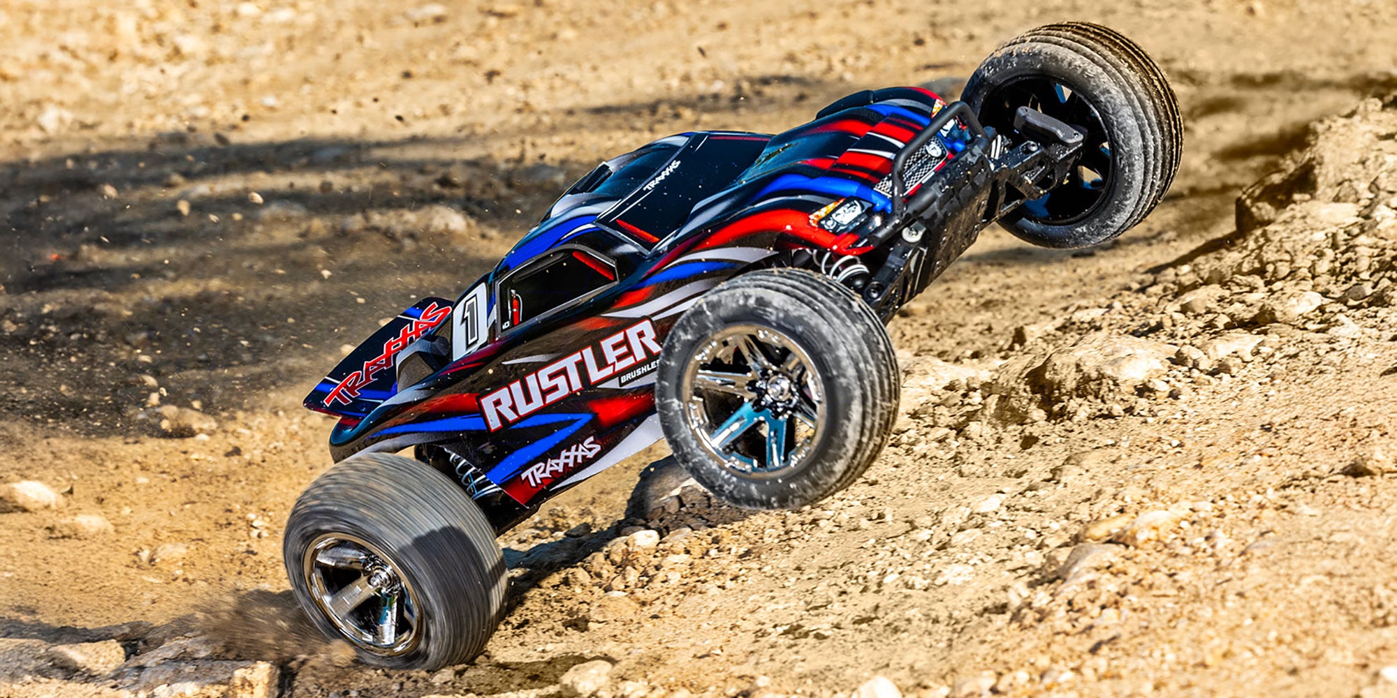 Traxxas Rustler Brushless fjernstyret bil i blå og orange set fra siden med grove offroad-dæk.