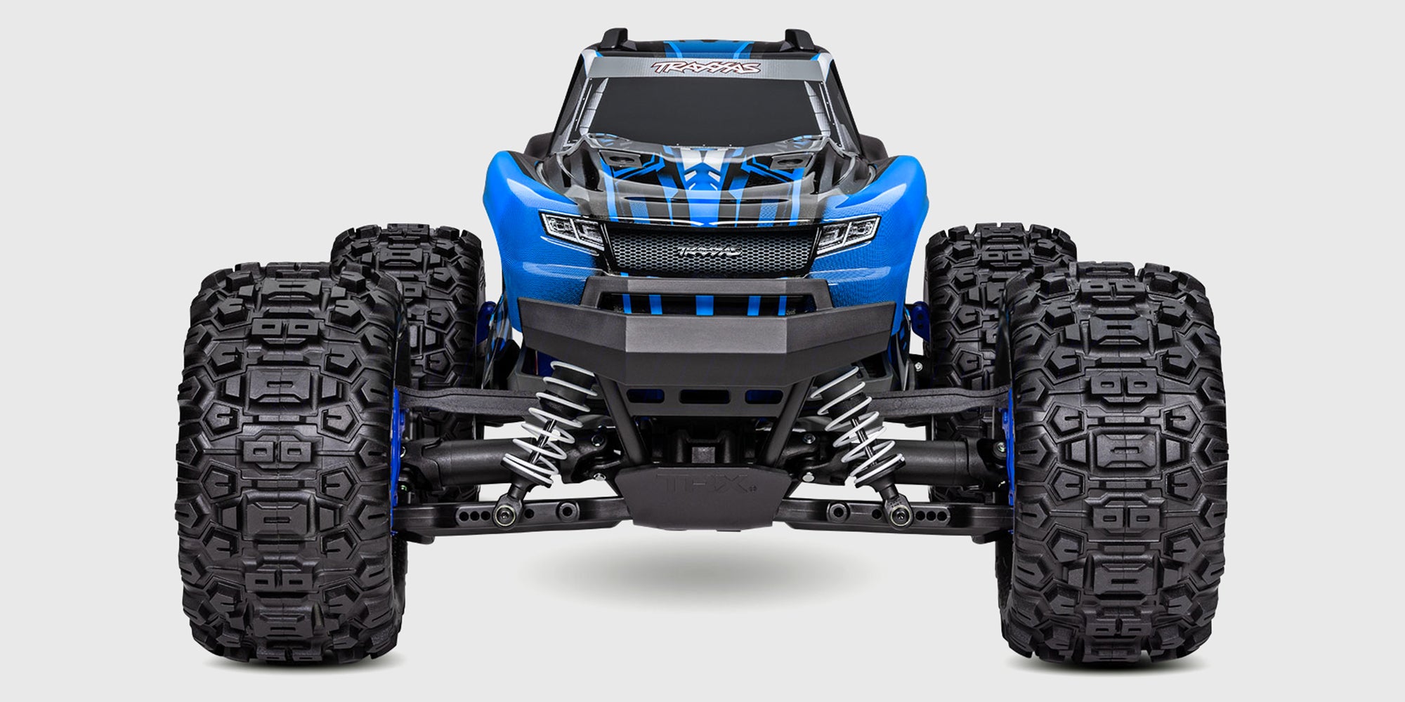 Traxxas Stampede 4x4 BL-2S monster truck i action gennem vand med store sprøjt og terrængående dæk.