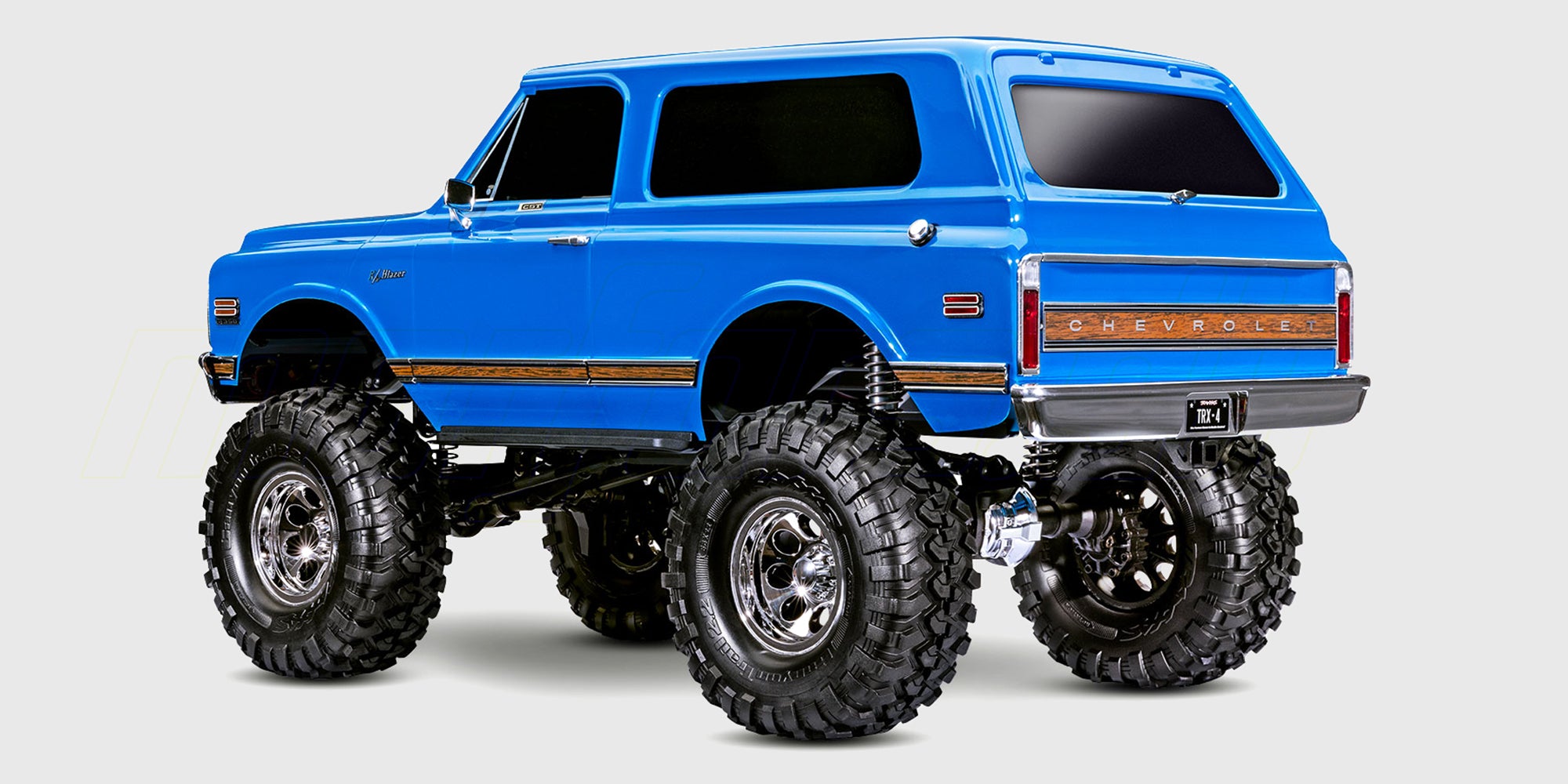 Traxxas TRX-4 Chevrolet K5 Blazer i rød og hvid set forfra mens den kører i terræn.