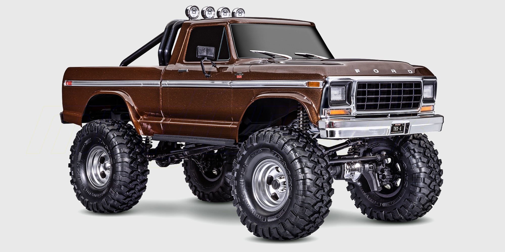 Traxxas TRX-4 Ford F-150 Ranger XLT i blå og hvid parkeret i råt terræn.