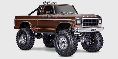 Traxxas TRX-4 Ford F-150 Ranger XLT i blå og hvid parkeret i råt terræn.