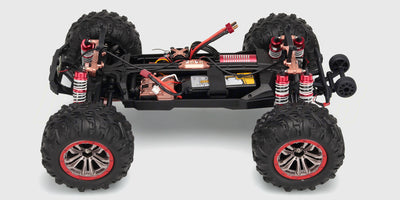 Chassis af XLH Race Truck med brushless motor og rød affjedring vist uden karrosseri på hvid baggrund.